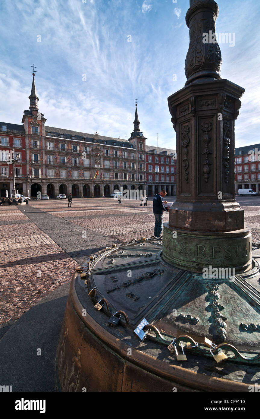 Good luck padlocks locked to the base of a bronze street lamp in The Plaza Mayor, Madrid, Spain. Stock Photo