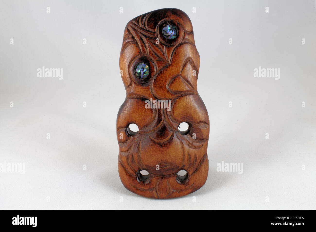 Maori wood carving of Tiki in a light tent with white background.  From Rotorua, New Zealand Stock Photo