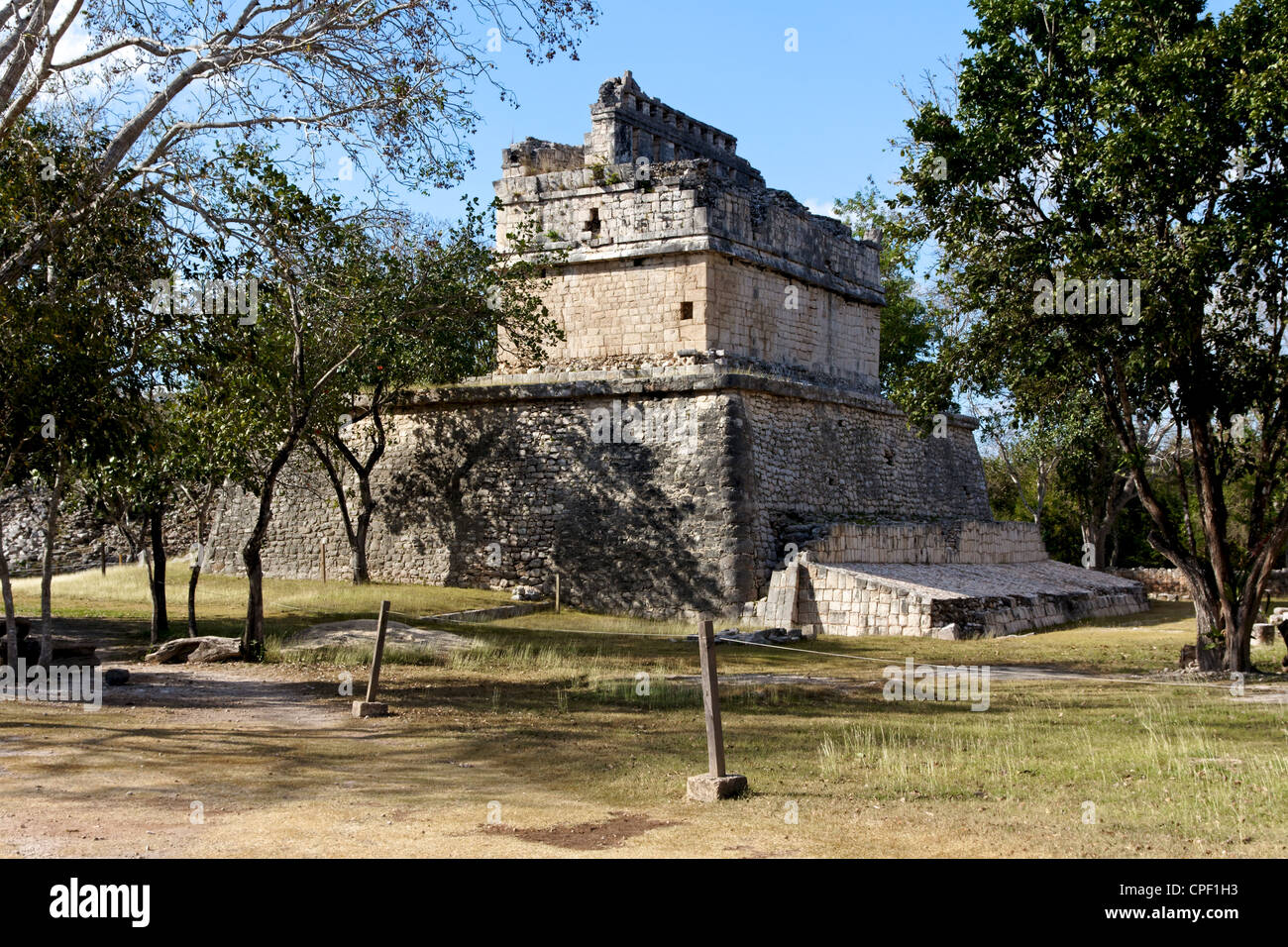 Ruin of a small Mayan structure among trees at the archeological site of Chichen Itza, Yucatan, Mexico. Stock Photo