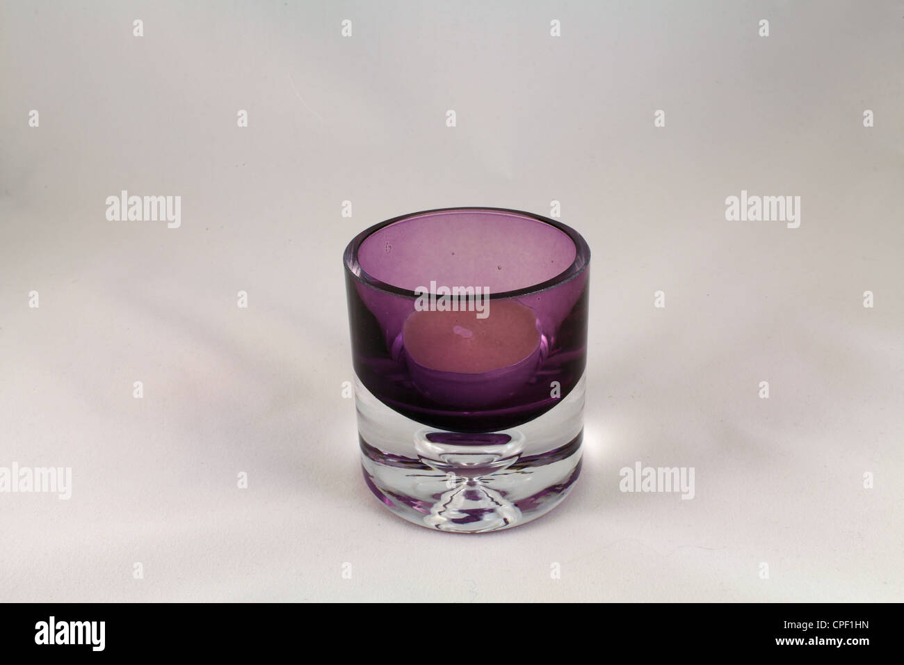 Purple candle holder with tea light in a light tent with white