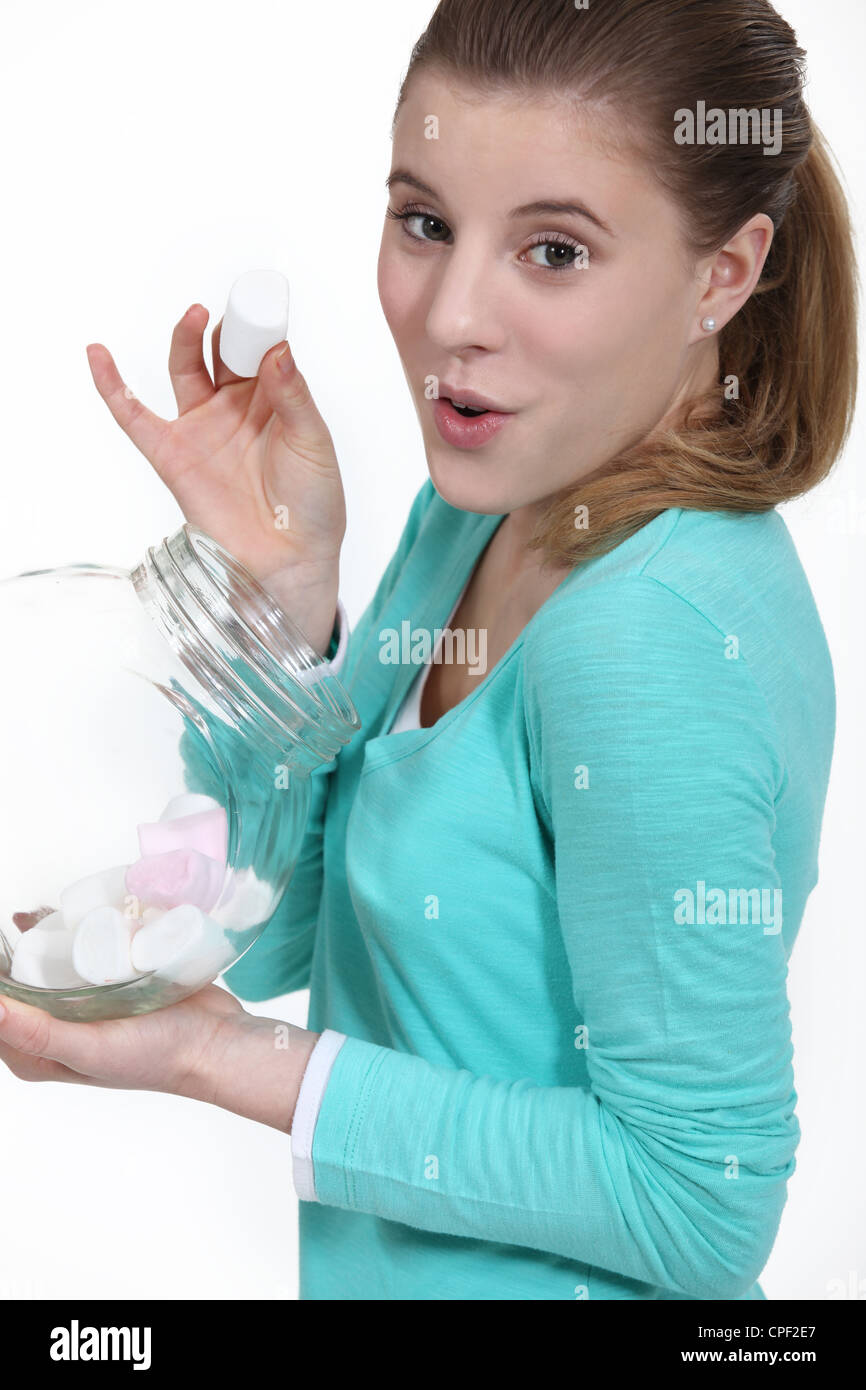 Cheeky woman eating marshmallow from jar Stock Photo Alamy