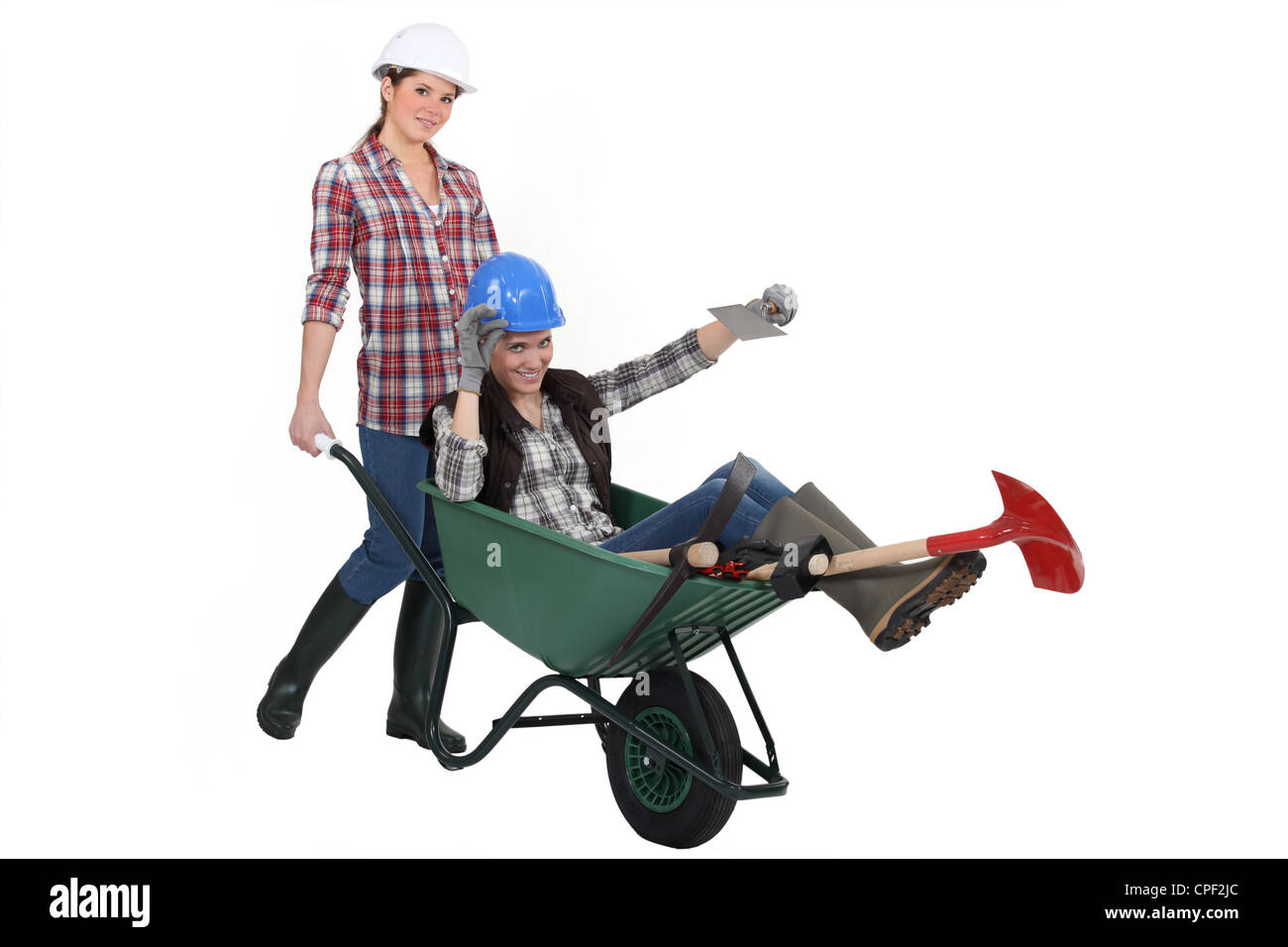 Two women messing around wuth wheelbarrow Stock Photo - Alamy