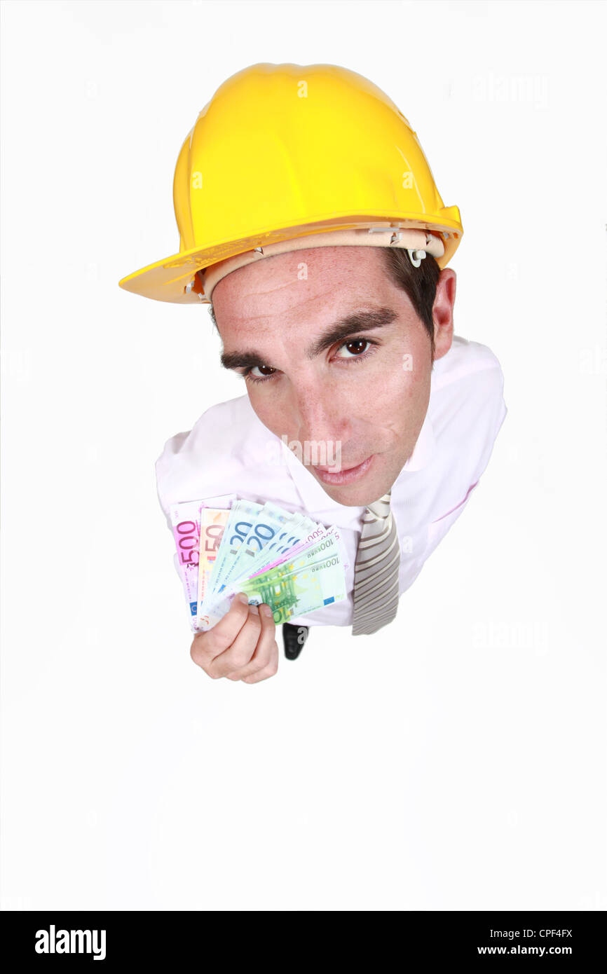 Man in a hardhat with cash Stock Photo