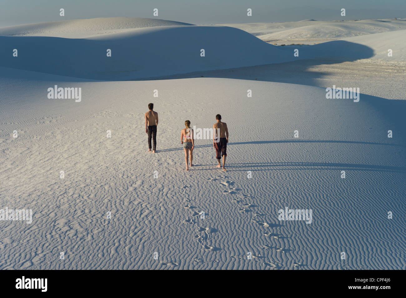 Three people walking in waves in the sand, White Sands National Monument, New Mexico, USA Stock Photo