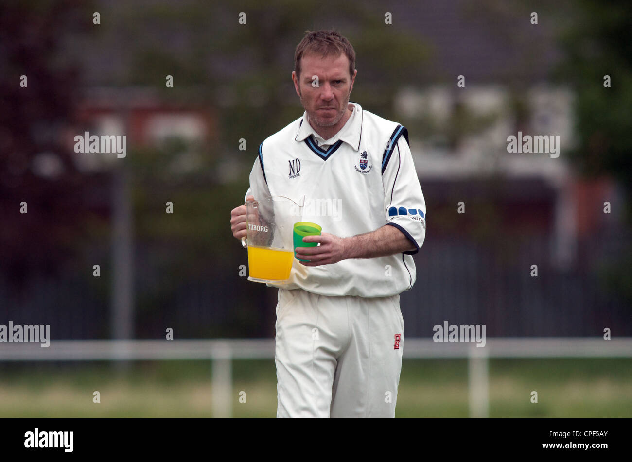 player carries soft drinks at cricket match drinks break Stock Photo