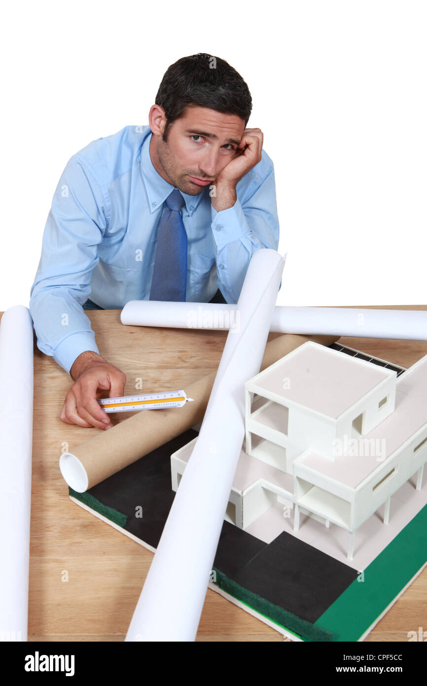 Dejected architect sitting at his desk Stock Photo