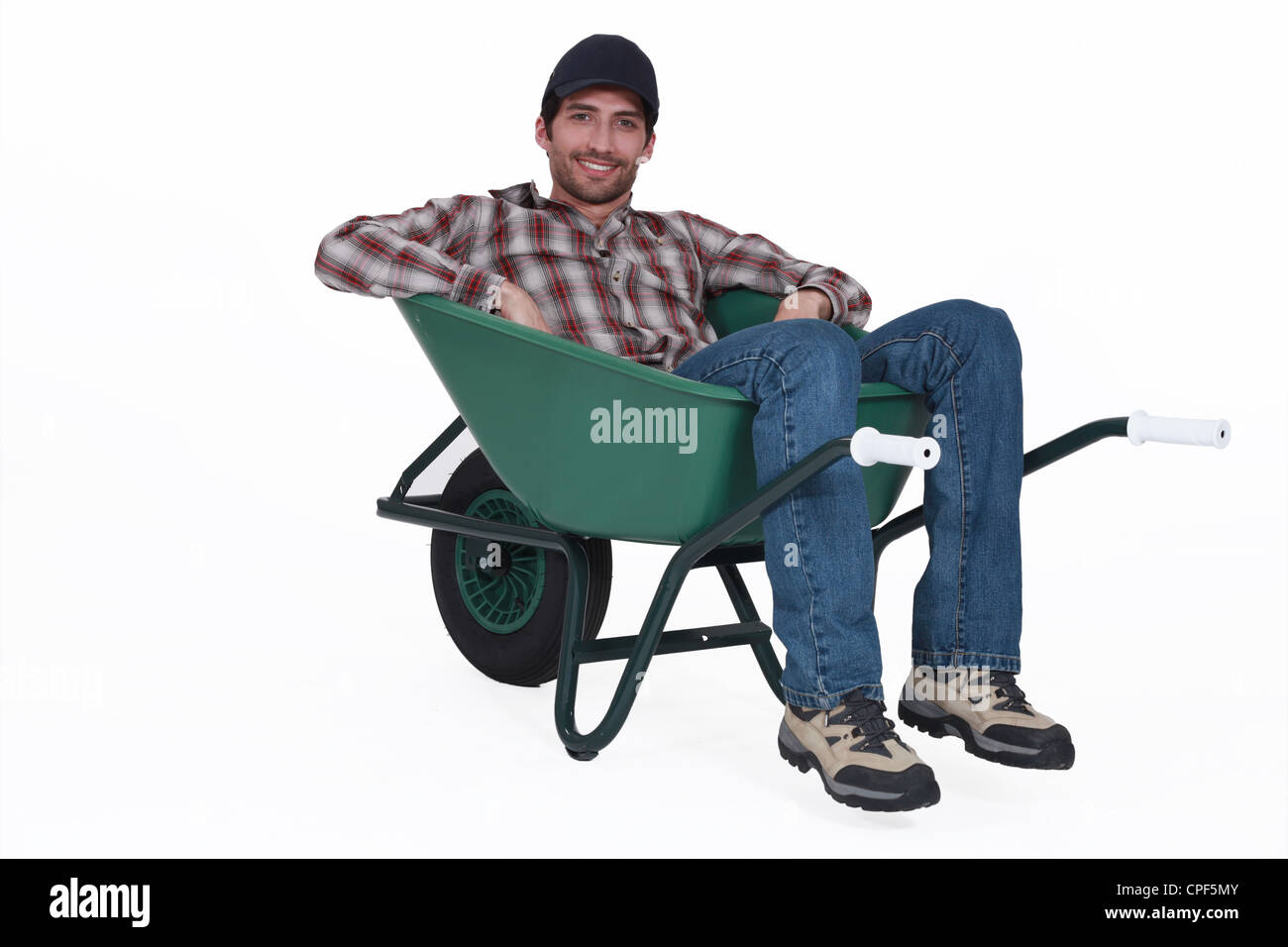 A man resting in a wheelbarrow Stock Photo Alamy