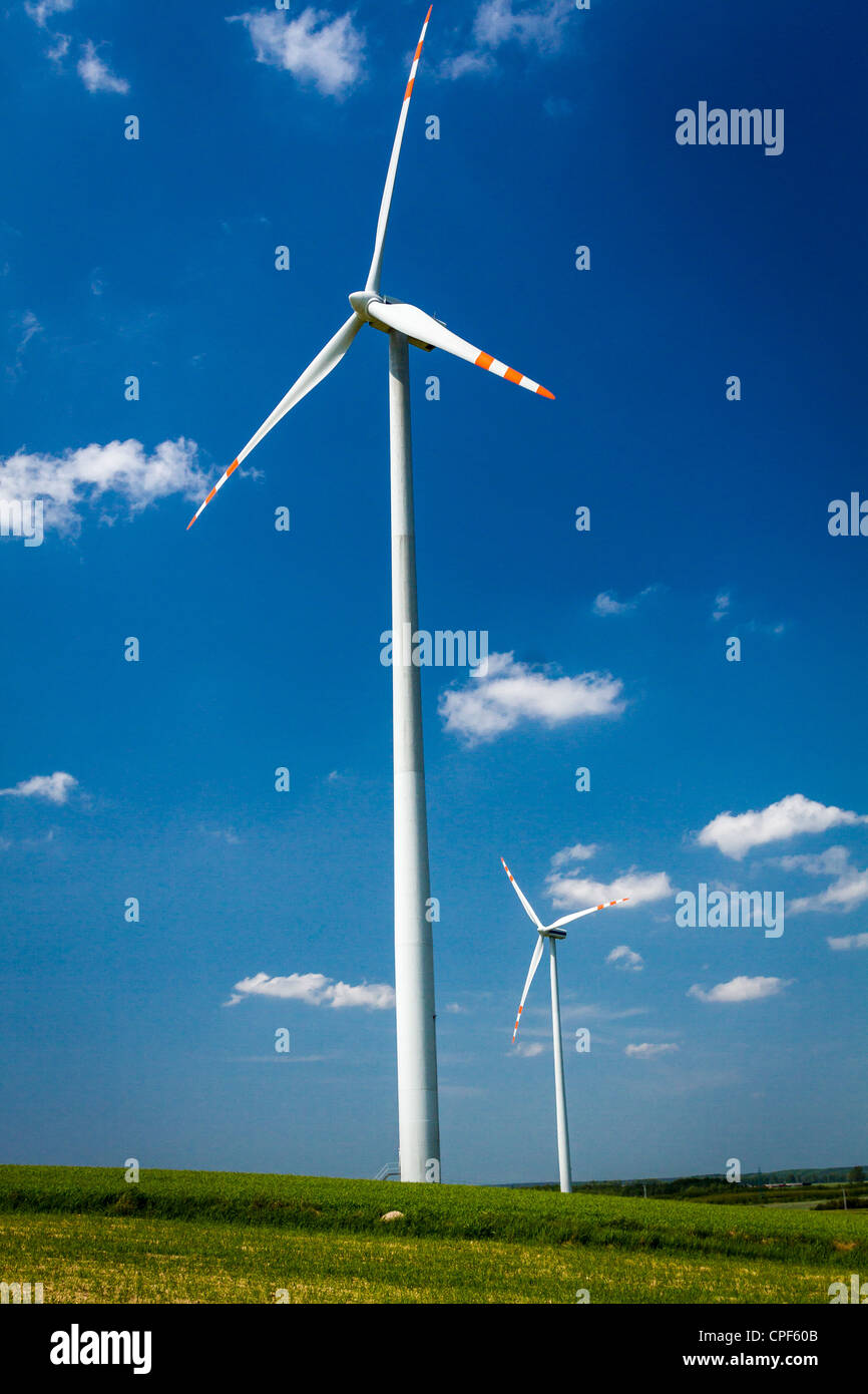 Wind turbines on green field with blue sky background Stock Photo - Alamy