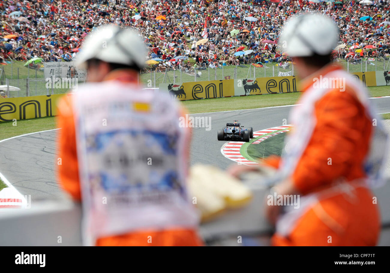 car passes through curve in front of grandstand filled with spectators ...