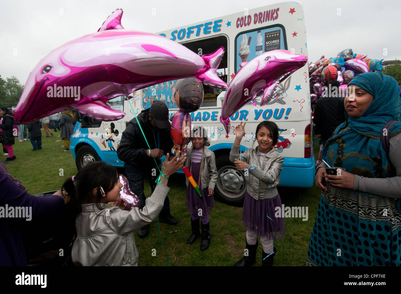 Boishakhi Mela, celebration for Bangladesh New Year. Family with pink dolphin balloons buying ice-creams Stock Photo