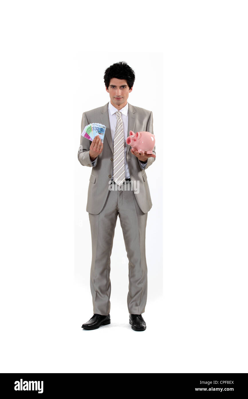 Man saving his money in a piggy bank Stock Photo - Alamy