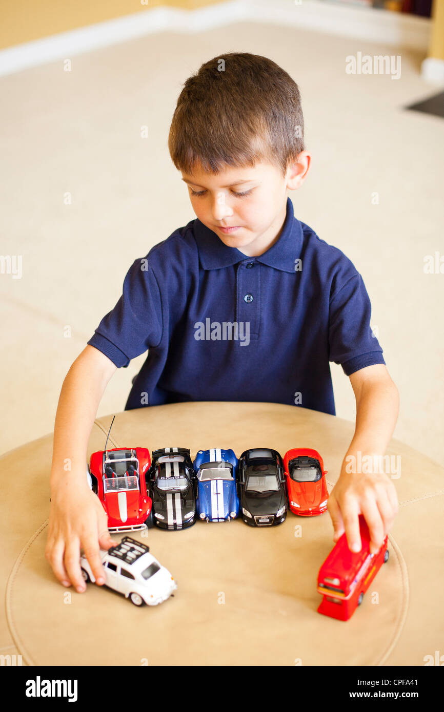 Boy playing with toy cars Stock Photo - Alamy