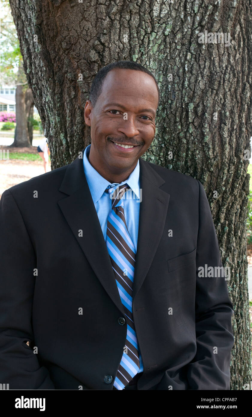 Black african american man in 40s dressed in business suit portrait  outdoors near tree Stock Photo - Alamy