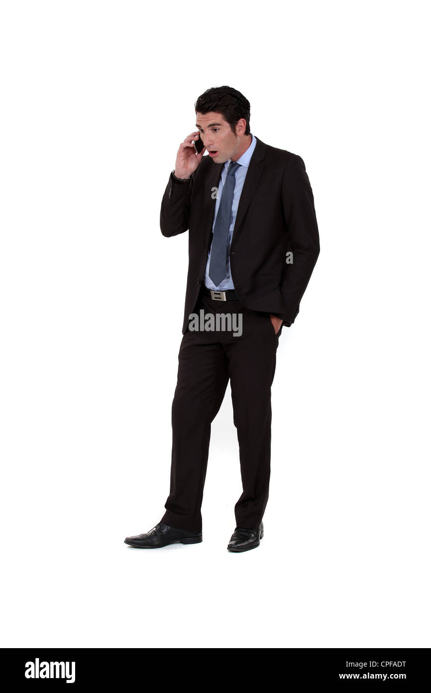 Businessman receiving shocking news over the telephone Stock Photo