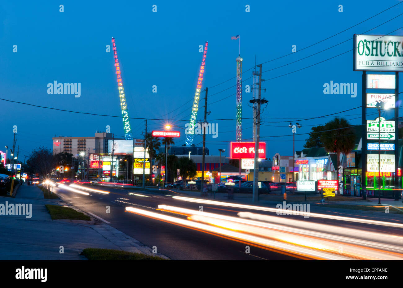 Twilight night shot of the tourist area of International Drive in Orlando Florida with colorful traffic and bungee jumping poles Stock Photo