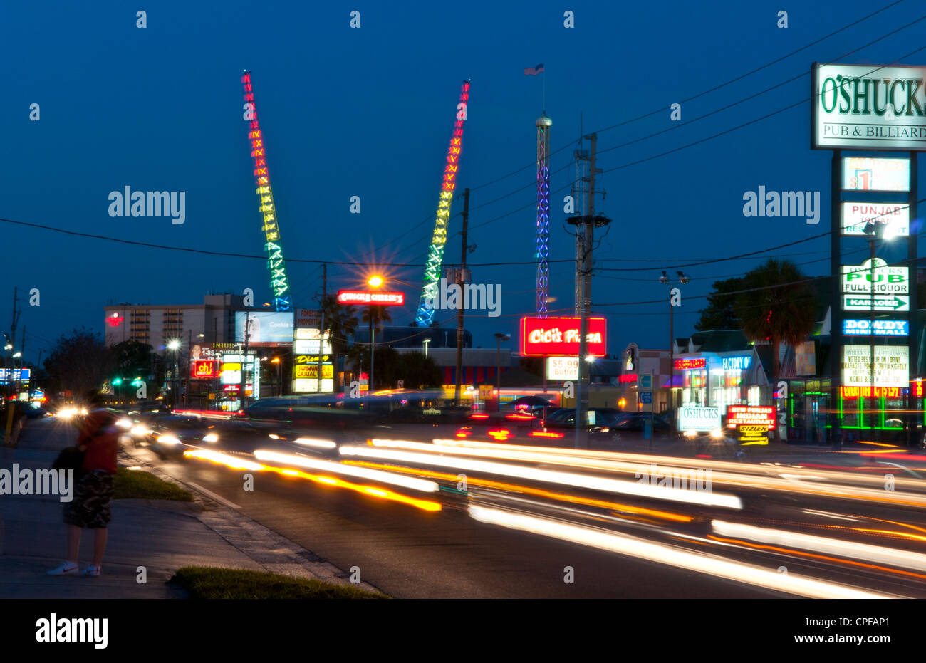 Twilight night shot of the tourist area of International Drive in Orlando Florida with colorful traffic and bungee jumping poles Stock Photo