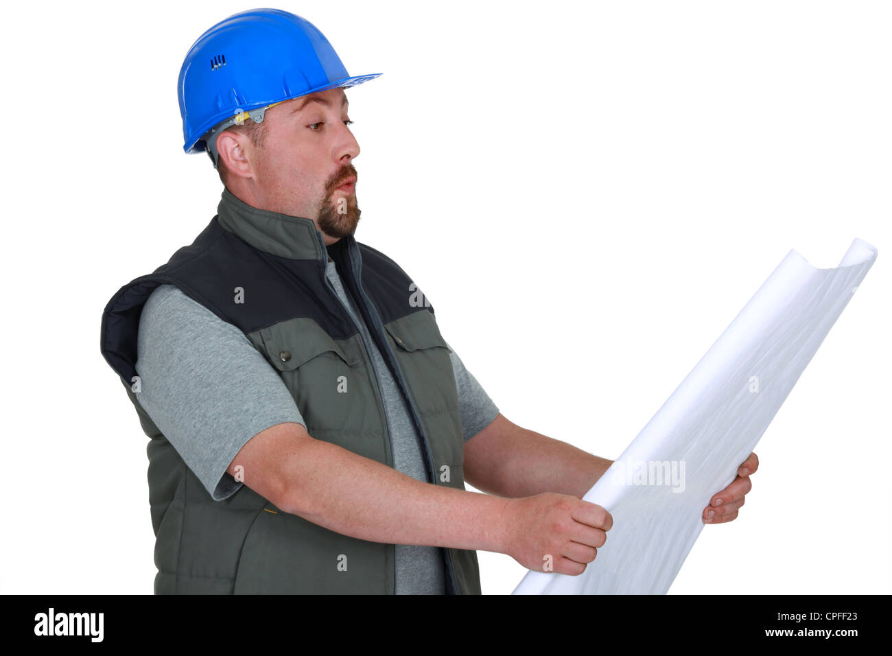 Surprised tradesman looking at a blueprint Stock Photo - Alamy