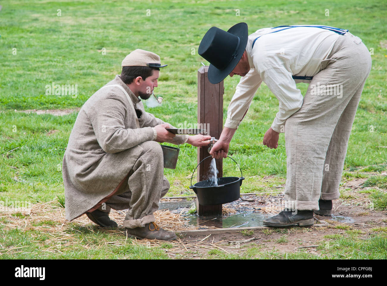 Two Confederate Army soldiers fill water from street  faucet,   War reenactment , Bensalem, USA Stock Photo