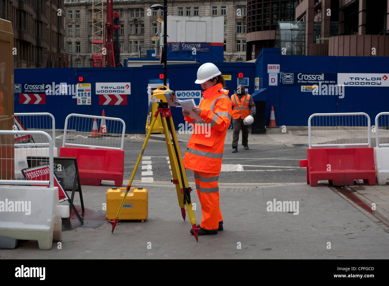 A young female engineer with surverying equipment working on Crossrail railway ouside  Liverpool Street Station London England UK  KATHY DEWITT Stock Photo