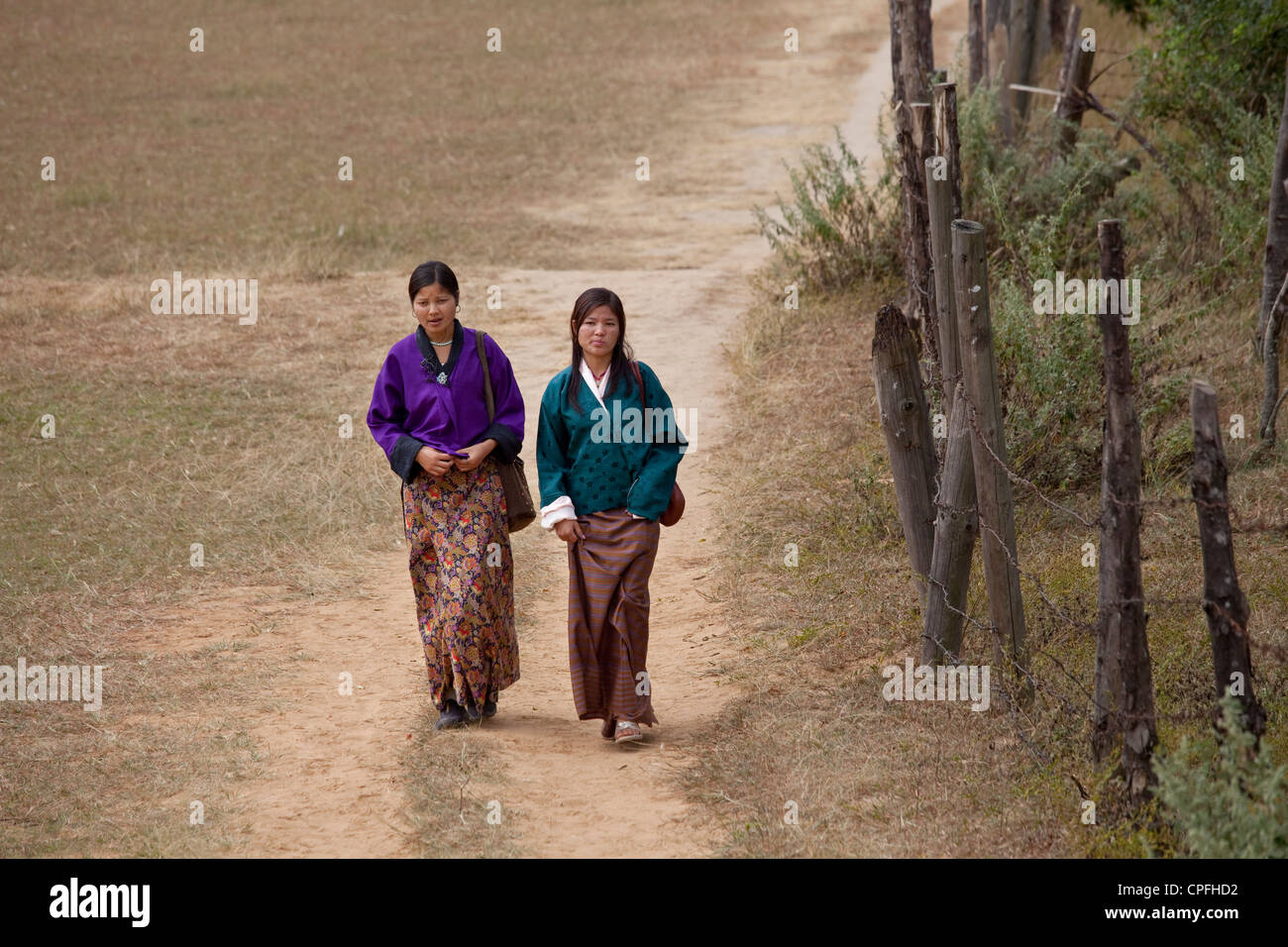 Young women walking to Chimi Lhakhang, the Temple of the Divine Madman. Stock Photo