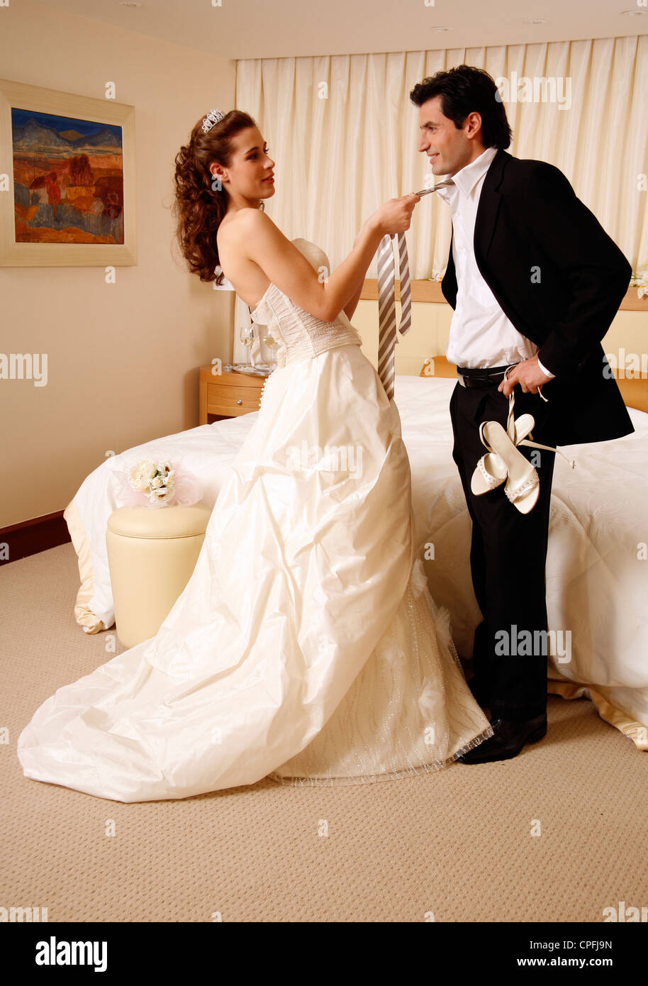 Bride and groom undressing in hotel room Stock Photo Alamy
