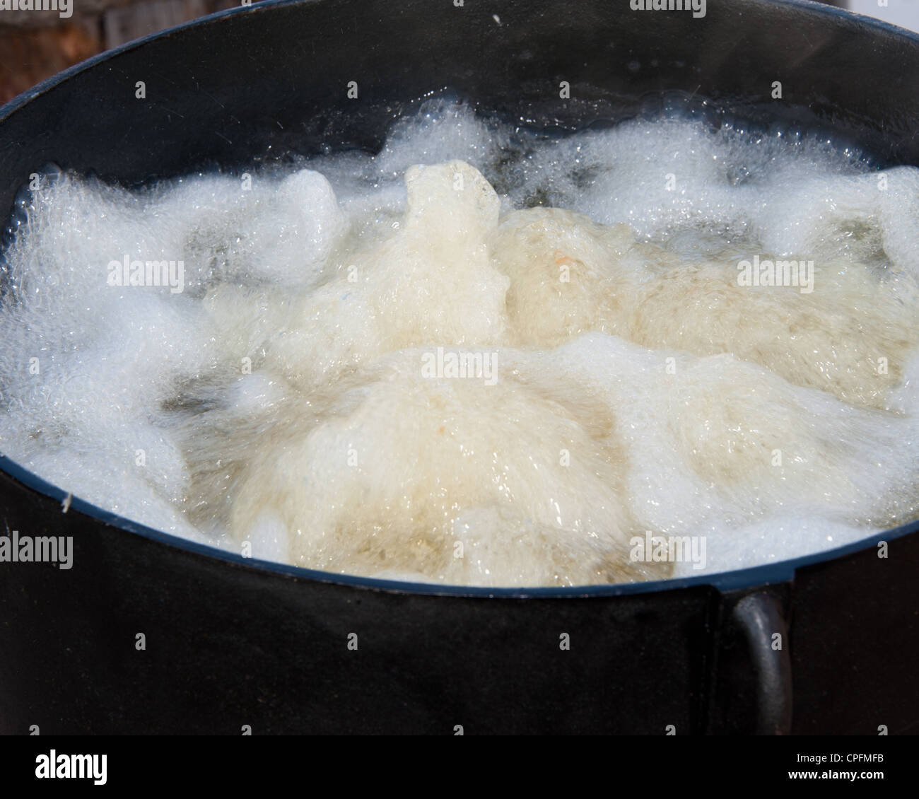 Boiling oil from the potato slices in the pitchfork fondue Stock Photo