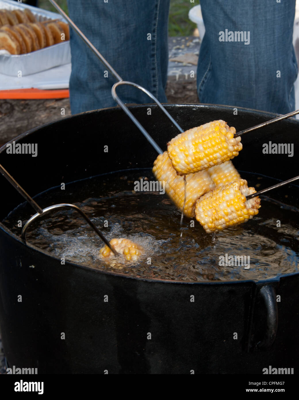 Cooking corn cobs in the pitchfork fondue Stock Photo Alamy