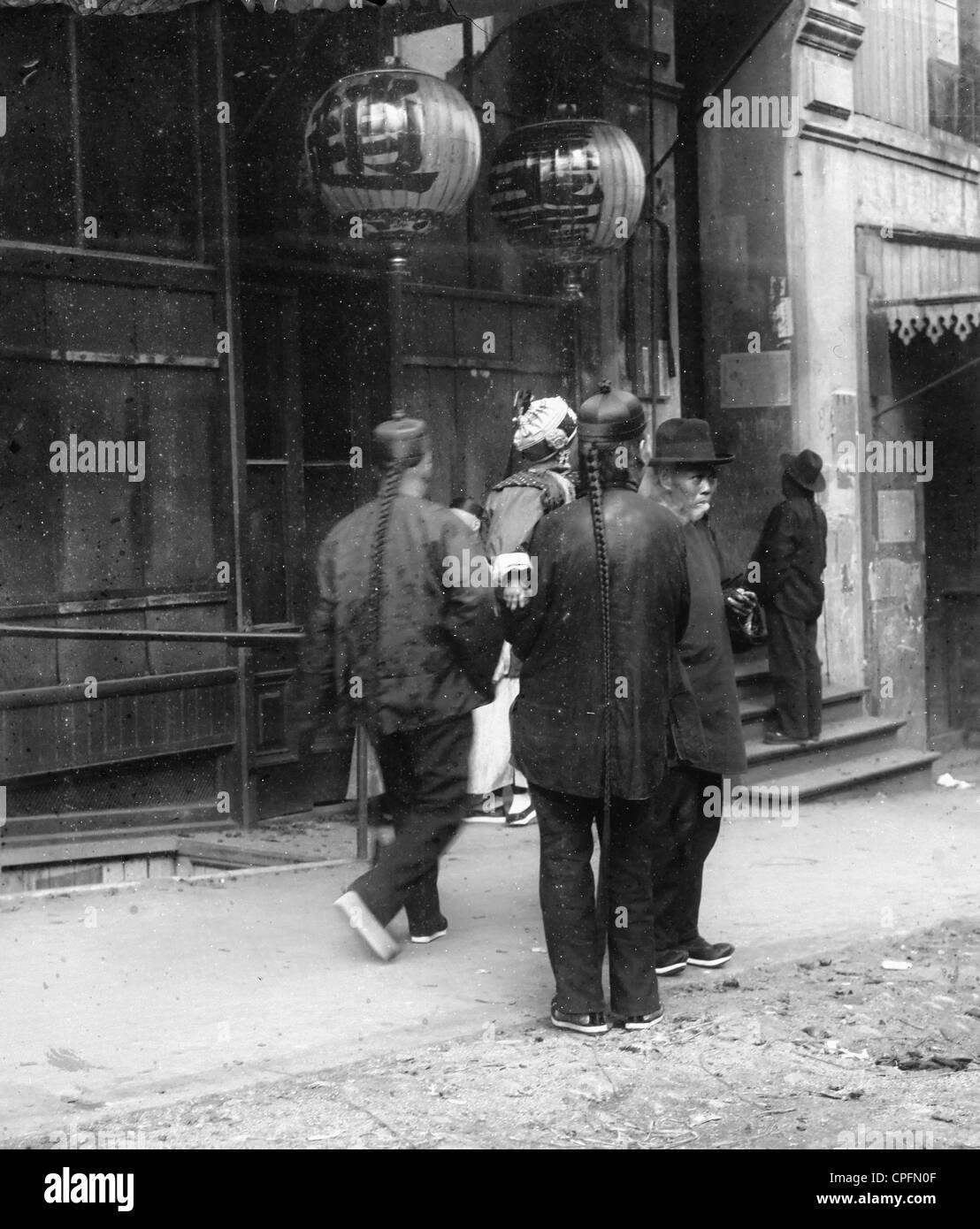 Two men, one holding a child, standing in the street, Chinatown, San Francisco, circa 1905 Stock Photo