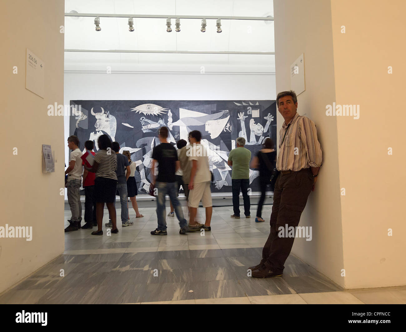 Visitors looking at 'Guernica' painting by Pablo Picasso at the Reina Sofia modern art museum in Madrid, Spain Stock Photo
