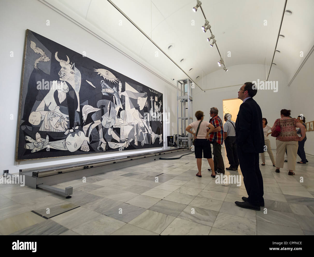 Visitors looking at 'Guernica' painting by Pablo Picasso at the Reina Sofia modern art museum in Madrid, Spain Stock Photo
