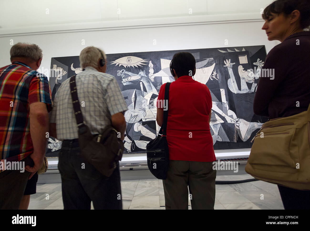 Visitors admiring the 'Guernica' painting by Pablo Picasso at the Reina Sofia modern art museum in Madrid, Spain Stock Photo