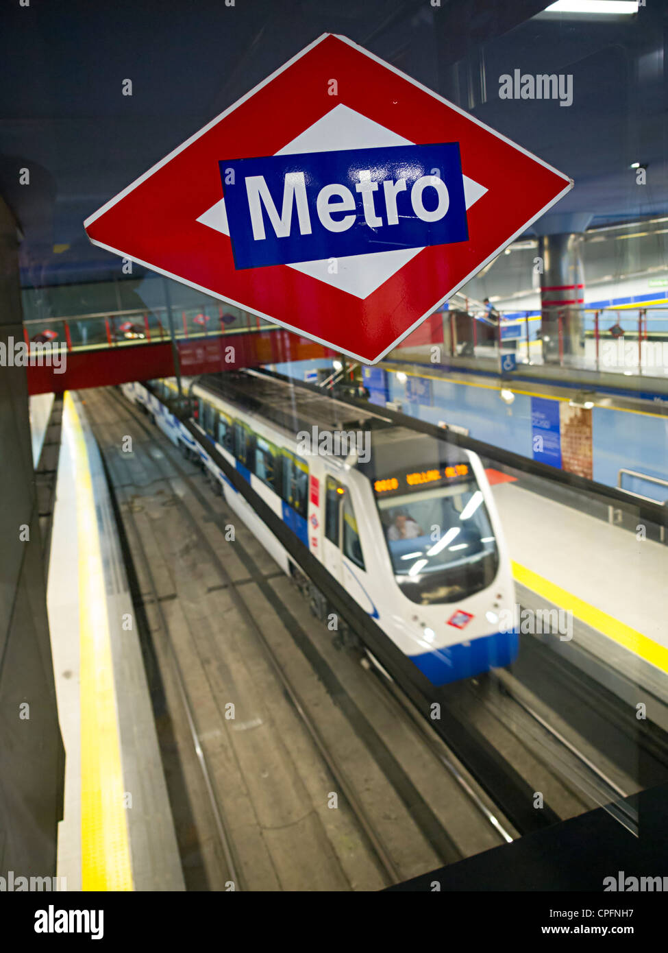 Motion blurred train at underground tube station platform in Madrid, Spain - shallow depth of field with focus on Metro logo Stock Photo