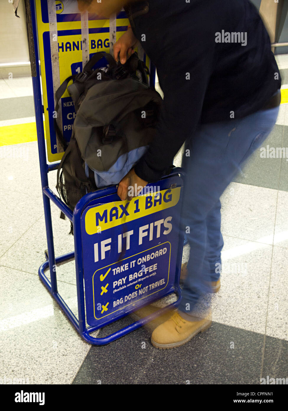 Person trying to fit backpack in Ryanair size limit Stock Photo