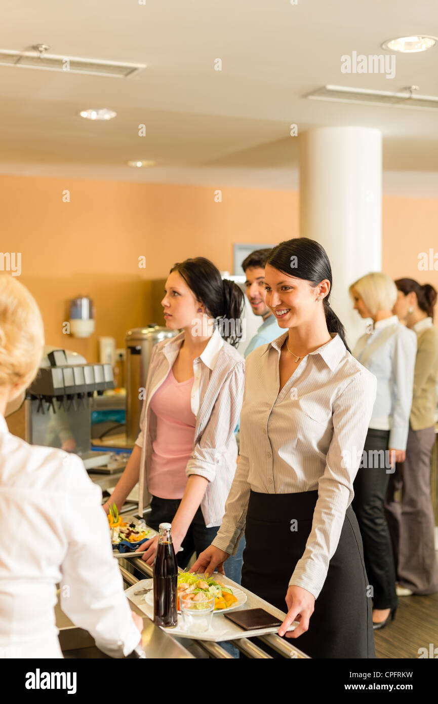 Cafeteria woman pay at cashier hold serving tray fresh food Stock Photo