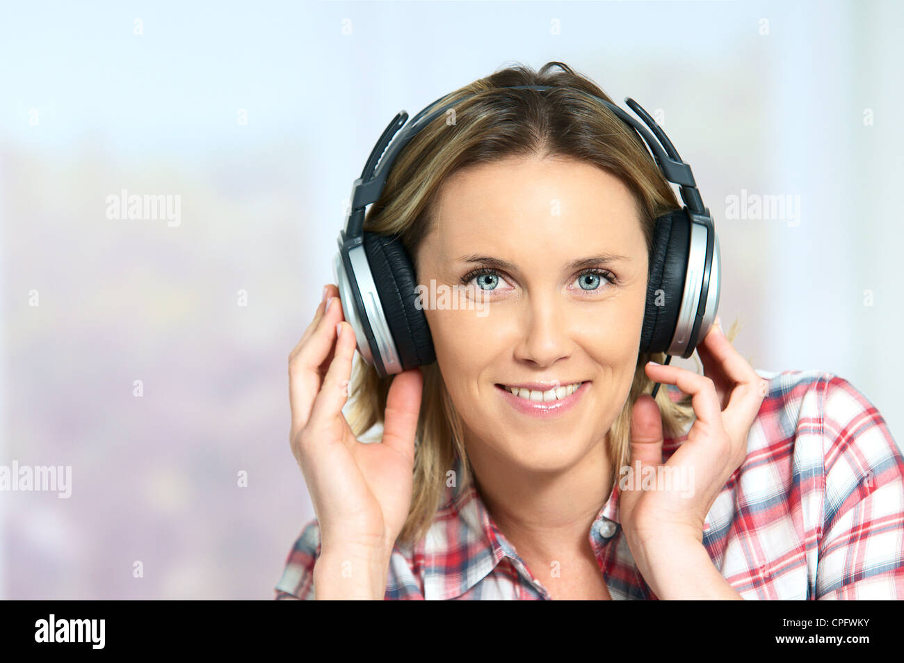 blond woman relaxing at home, listening music Stock Photo