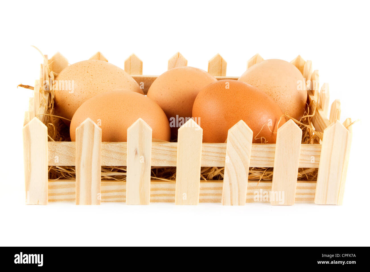 Box of eggs on straw in a wooden box on white Stock Photo