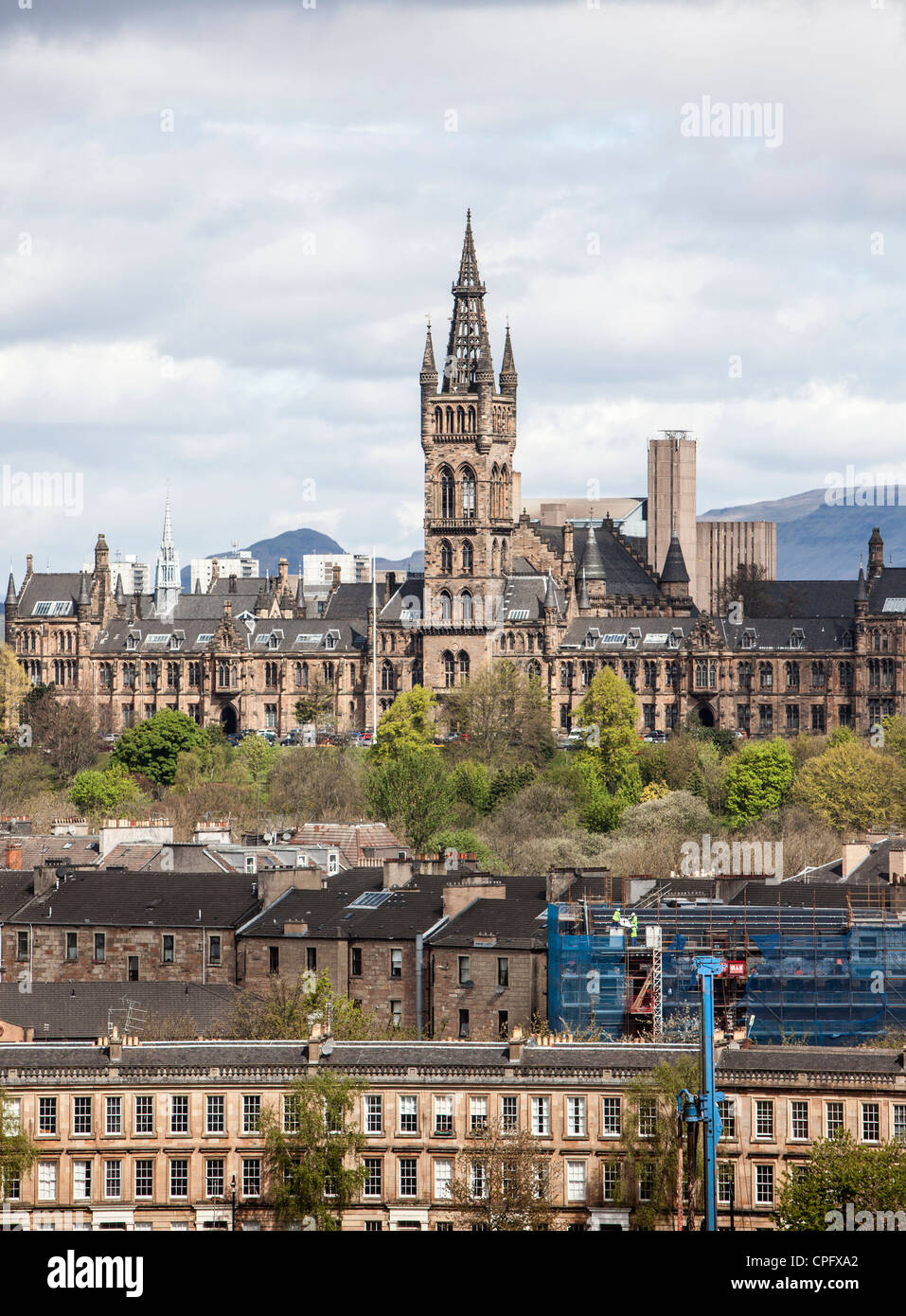 The University of Glasgow famous tower sitting above tenement blocks of flats and with the hills in the background. Stock Photo