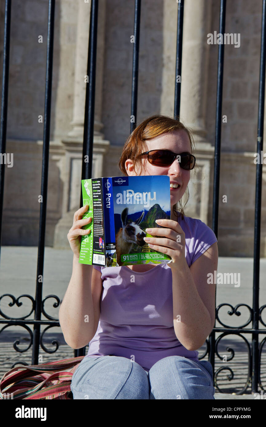 Woman Reading A Guide Woman reading Peru guide book Stock Photo - Alamy