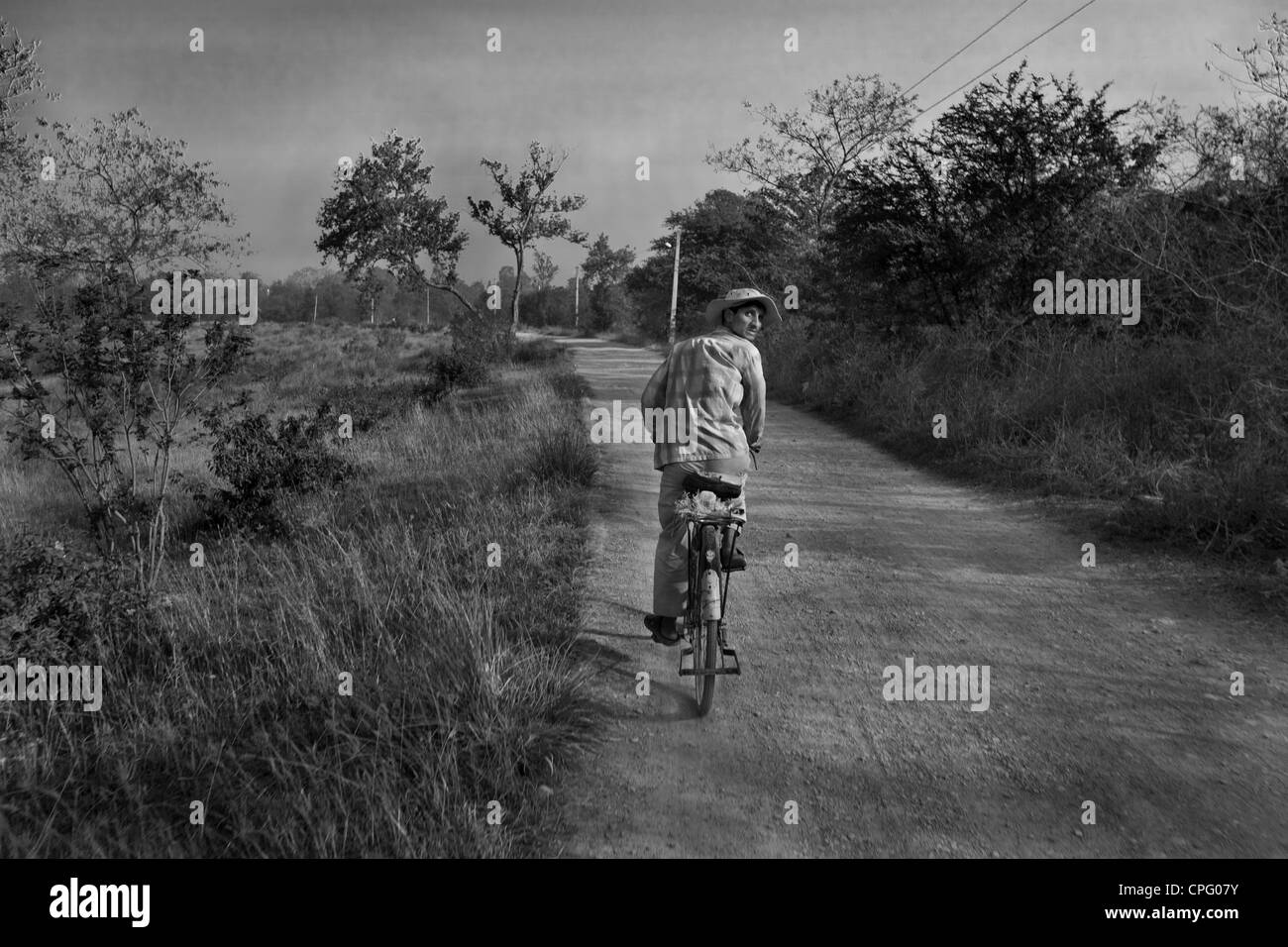 Man looking backwards while cycling, Lumbini, Nepal Stock Photo