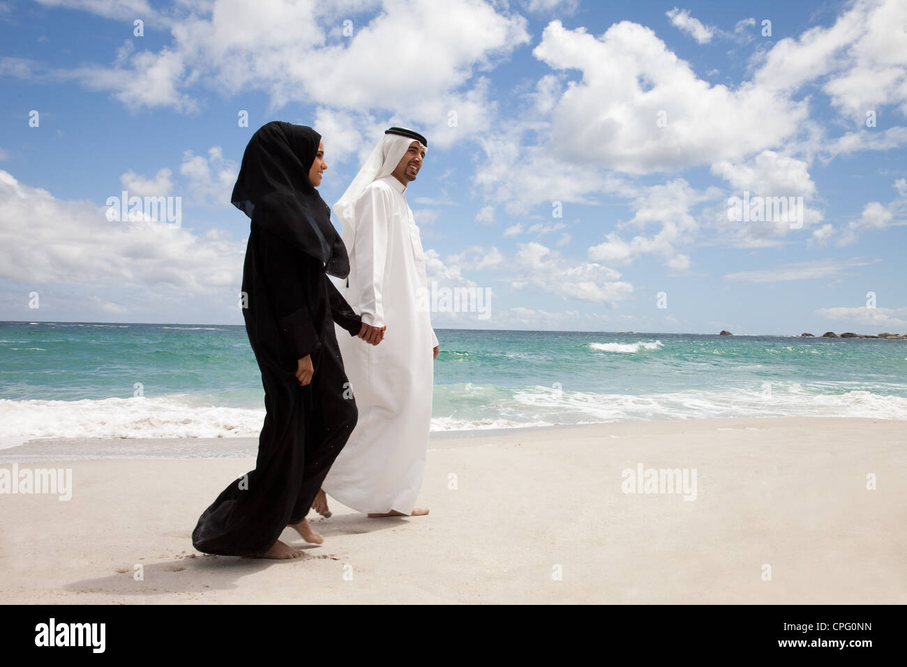 Young arab couple walking at the beach. Stock Photo