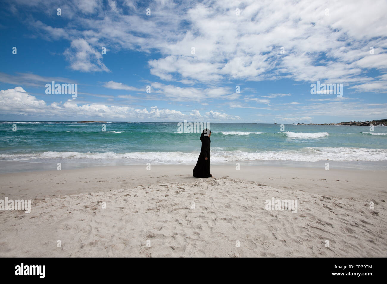 Arab woman walking at the beach. Stock Photo