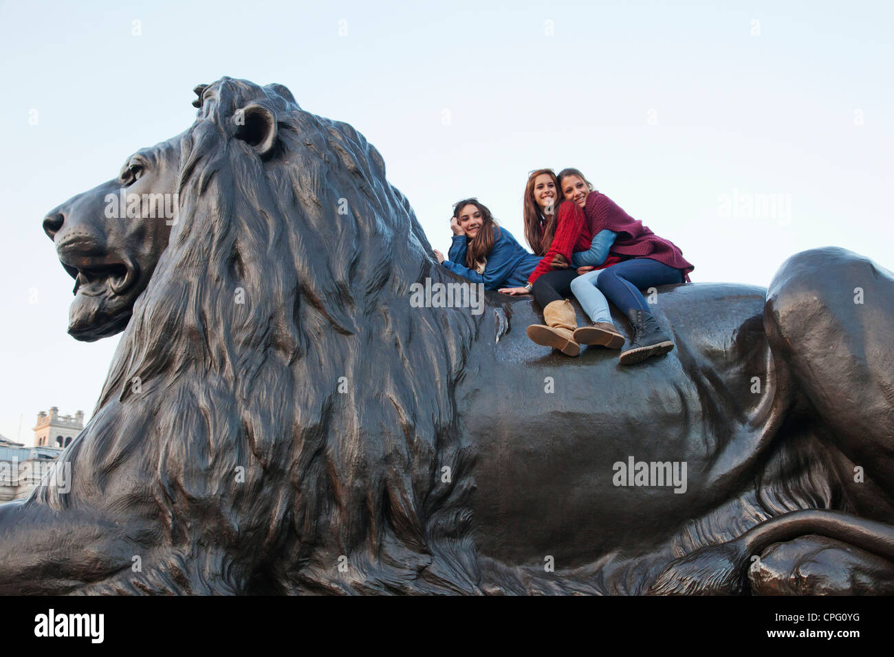 England, London, Trafalgar Square, Children posing on Lion Statue Stock Photo
