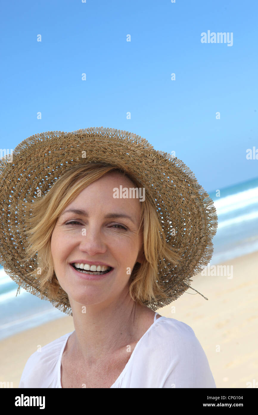 Smiling woman in a straw hat on the beach Stock Photo - Alamy