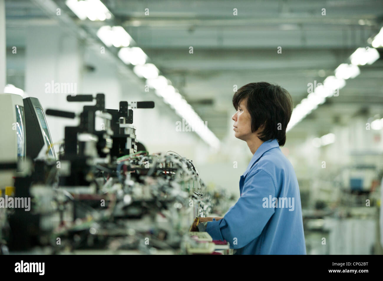 A worker assembles hand-held inventory computer devices on the assembly ...