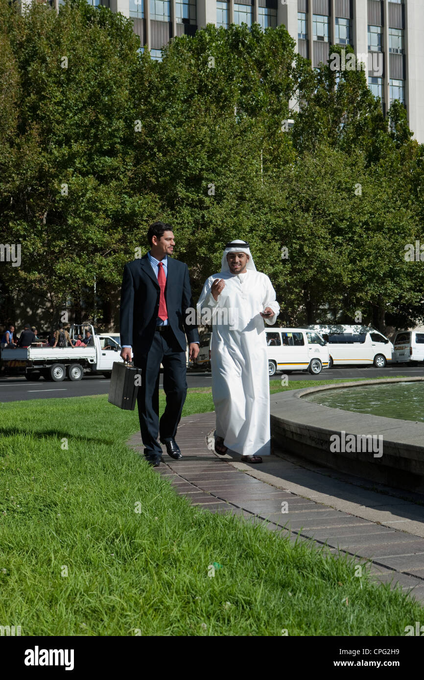 Two businessmen talking while walking at the street Stock Photo - Alamy
