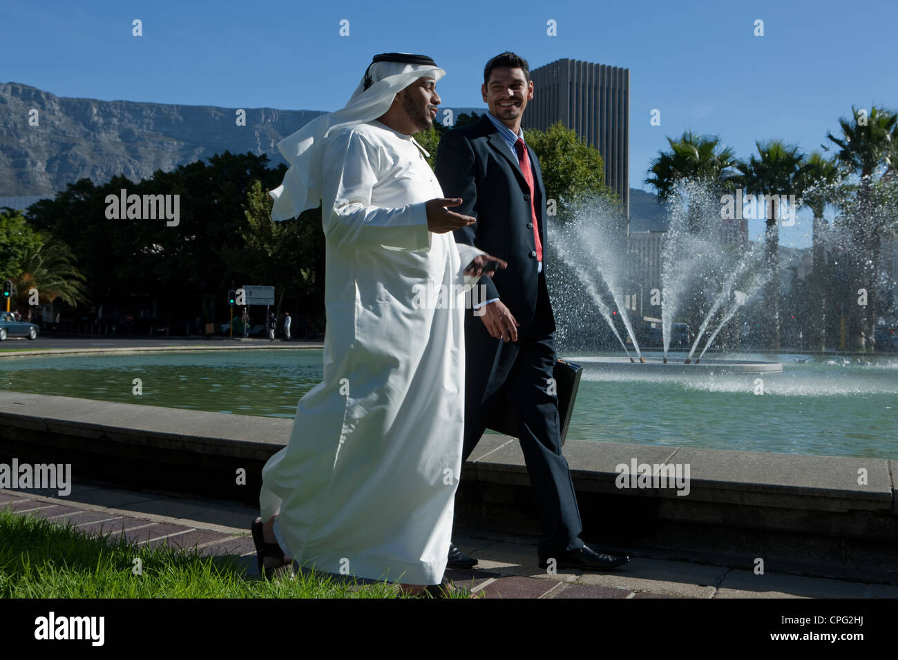 Two businessmen talking while walking at the street Stock Photo - Alamy
