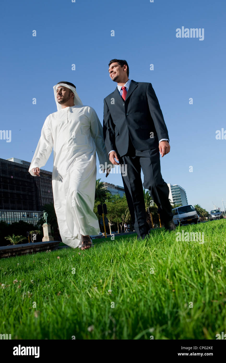 Two businessmen talking while walking at the street Stock Photo - Alamy