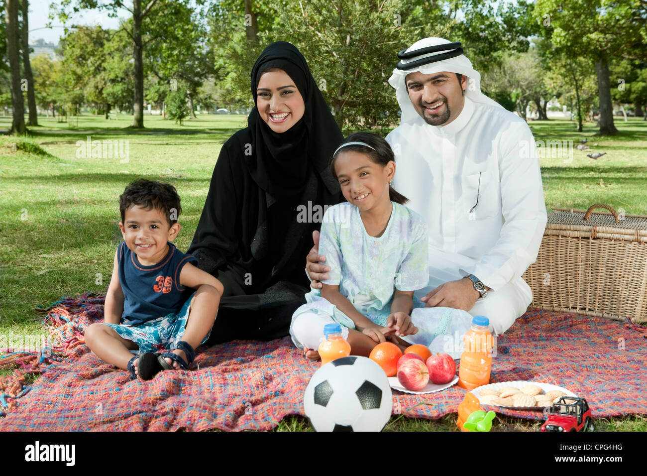 Portrait of arab family in the park, smiling. Stock Photo