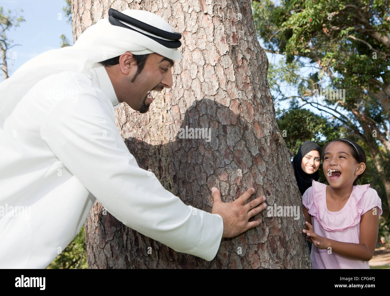 Arab family playing hide and seek in the park. Stock Photo