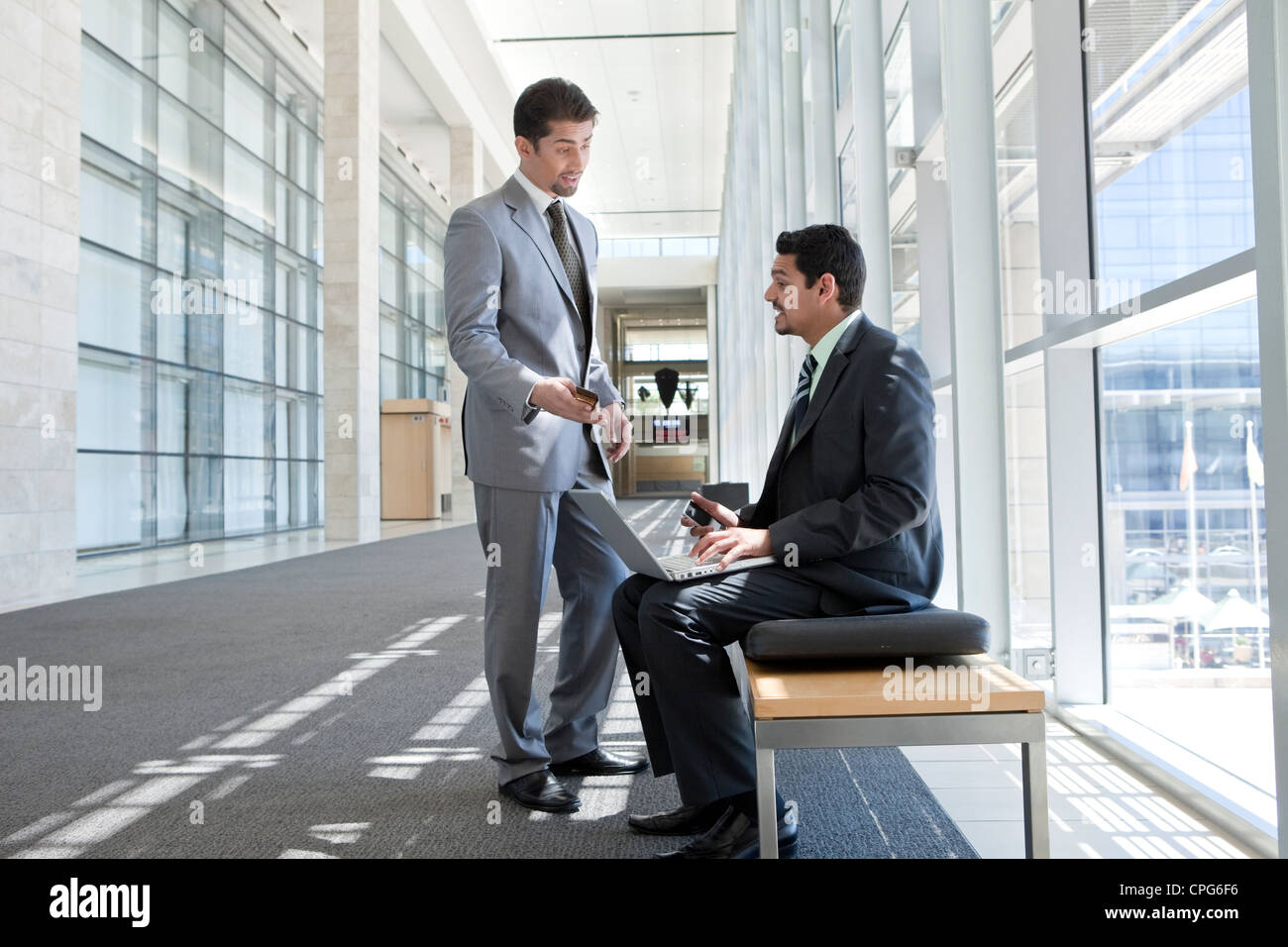 Two businessmen talking in the office hallway. Stock Photo
